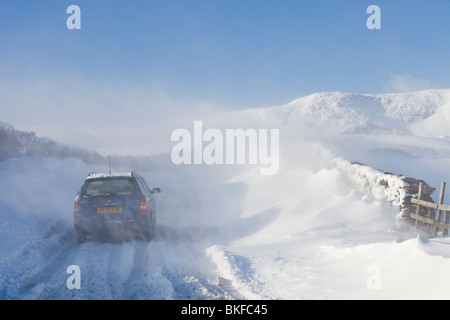 Une voiture est abandonnée sur l'Kirkstone pass road Windermere ci-dessus après qu'il est bloqué par la neige par le vent et les embruns, au Royaume-Uni. Banque D'Images