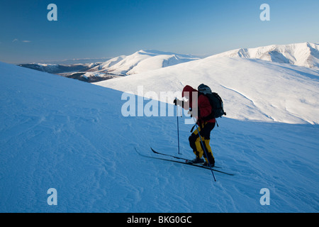 Mike Garrot à l'aide de skis de fond à descendre le pic de Grand Dodd, à 2800 pieds, sur la fin de la gamme Helvellyn, UK Banque D'Images