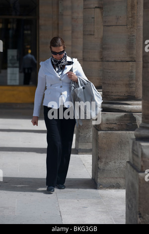 Femme à la mode se promonant dans des arches voûtées des jardins du jardin du Palais Royale à Paris, France, scène de rue parisienne personnes, jour ensoleillé Banque D'Images