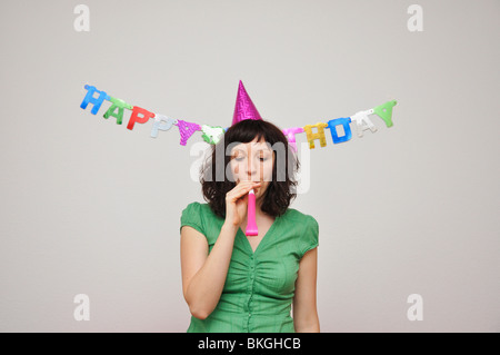 Young woman blowing soufflante bruit Banque D'Images