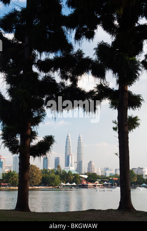 Les Tours Petronas vu entre 2 arbres au lac Titiwangsa. Banque D'Images