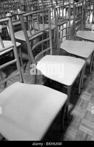 Des rangées de sièges vides à un lieu de mariage, sur un plancher de bois. Noir et blanc traitement appliqué. Banque D'Images