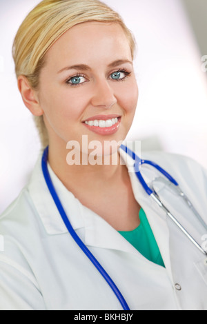 Un joli sourire femme médecin portant une blouse blanche et stéthoscope dans un hôpital. Banque D'Images