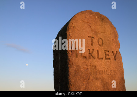 La lune se lève sur un panneau en pierre ou jalon sur 'Rombolds» ou Ilkley Moor, dans le West Yorkshire, Angleterre, Royaume-Uni Banque D'Images