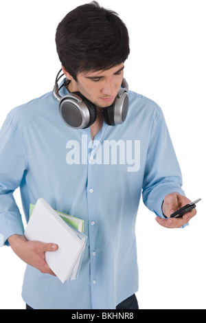 L'envoi de message texte Male student holding books sur fond blanc Banque D'Images