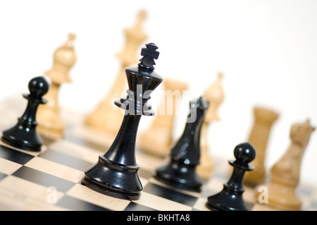 Chess.roi noir debout. Roi noir protégé par Knight et pions contre l'approche de pièces blanches Banque D'Images