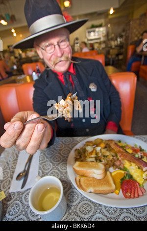 L'homme habillé en 1800 maréchal ville mange 'Hangtown Fry,' un repas copieux qui date de la ruée vers l'or du milieu des années 1800 en Californie Banque D'Images