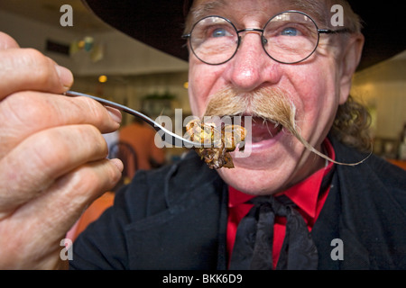 L'homme habillé en 1800 maréchal ville mange 'Hangtown Fry,' un repas copieux qui date de la ruée vers l'or du milieu des années 1800 en Californie Banque D'Images