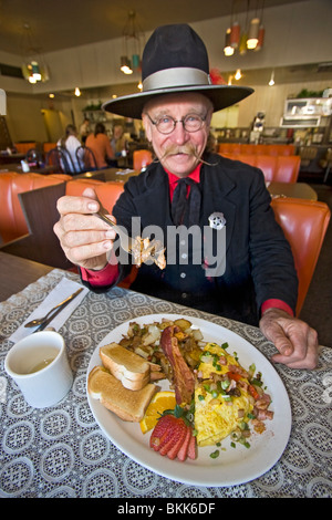 L'homme habillé en 1800 maréchal ville mange 'Hangtown Fry,' un repas copieux qui date de la ruée vers l'or du milieu des années 1800 en Californie Banque D'Images