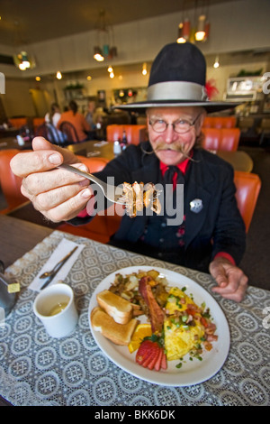 L'homme habillé en 1800 maréchal ville mange 'Hangtown Fry,' un repas copieux qui date de la ruée vers l'or du milieu des années 1800 en Californie Banque D'Images