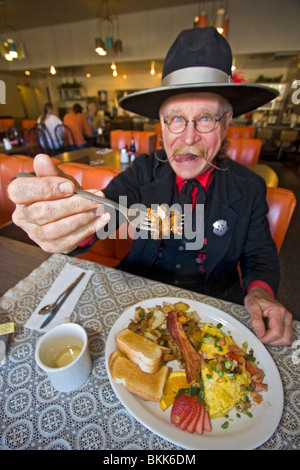 L'homme habillé en 1800 maréchal ville mange 'Hangtown Fry,' un repas copieux qui date de la ruée vers l'or du milieu des années 1800 en Californie Banque D'Images