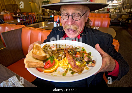 L'homme habillé en 1800 maréchal ville mange 'Hangtown Fry,' un repas copieux qui date de la ruée vers l'or du milieu des années 1800 en Californie Banque D'Images