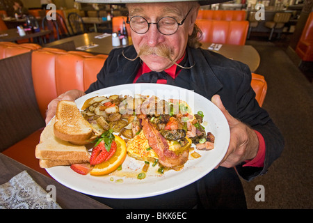 L'homme habillé en 1800 maréchal ville mange 'Hangtown Fry,' un repas copieux qui date de la ruée vers l'or du milieu des années 1800 en Californie Banque D'Images