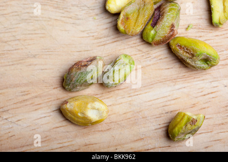 Une pile de pistaches non décortiquées sur une planche en bois Banque D'Images