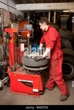 Un travailleur de garage changer un pneu sur une jante de roue de voiture Banque D'Images