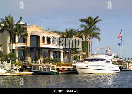 Les luxueux yachts de plusieurs millions de dollars et de maisons en bord de ligne des résidents riches Newport Harbor à Newport Beach en Californie du Sud, USA. Banque D'Images