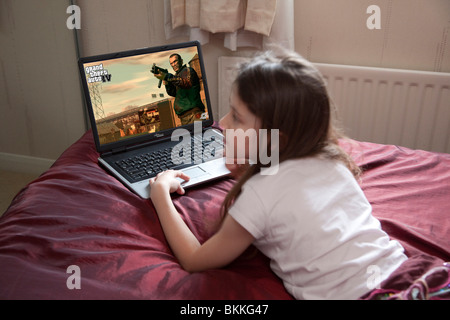 Jeune fille jouant le jeu Grand Theft Auto IV dans sa chambre à coucher Banque D'Images