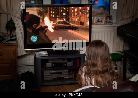 Jeune fille jouant le jeu Grand Theft Auto IV dans la salle de séjour Banque D'Images