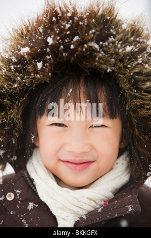 Chinese girl avec capuche fourrure couverte de neige Banque D'Images