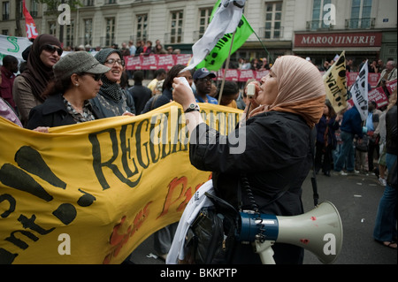 Des groupes de femmes diverses défilant avec bannière de protestation, manifestant à 1 mai, démonstration du jour de mai, Paris, France, « sans papiers », Femme musulmane menant avec Megaphone dans la rue, migrants en Europe, droits des immigrants, femme dans le hajib, voile, migrants illégaux Banque D'Images