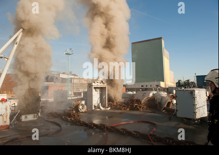 Ex Bateau de la marine américaine en feu dans le dock avec de grandes quantités de fumée à tenir Banque D'Images