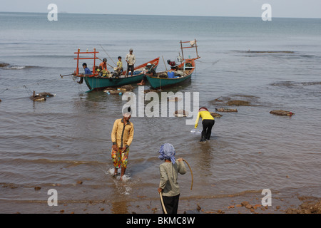 Tôt le matin, long tail- les bateaux de pêche sont amarrés au large de l'animation du marché du crabe à Kep, sur la côte sud-est du Cambodge Banque D'Images