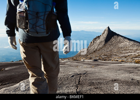 Randonneur sur Mt Kinabalu avec Pic du Sud à l'arrière-plan. Parc National de Kinabalu, Sabah, Bornéo, Malaisie. Banque D'Images