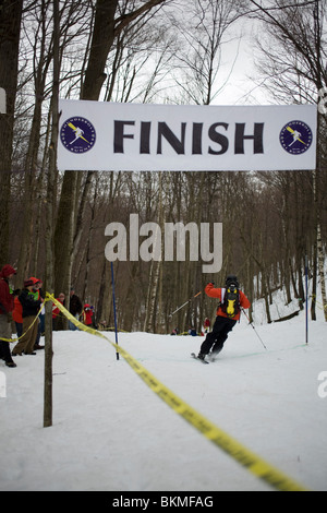 Un skieur aventureux traverse la ligne d'arrivée à la course de ski Thunderbolt en mars 2010 sur le mont Greylock, Adams, MA. Banque D'Images
