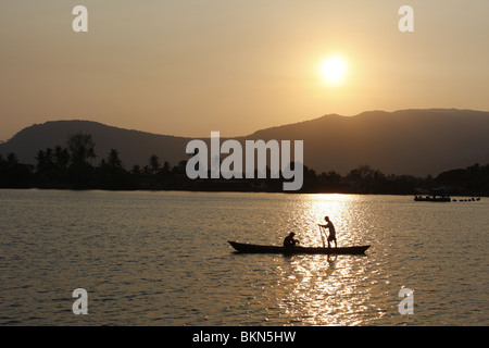 Un couple dans un bateau à rames sur la rivière à Kampot, Cambodge au coucher du soleil Banque D'Images