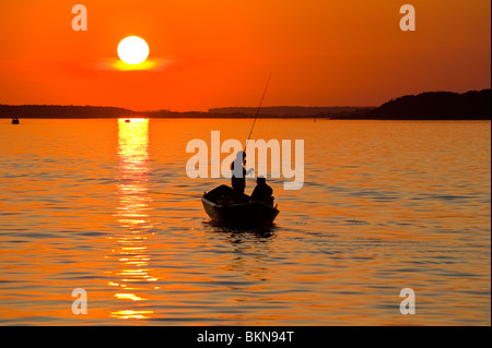 Silhouette de deux pêcheurs en bateau de pêche, plage Kolpinsee, coucher et au lever du soleil, 102, Muritz, Mecklembourg Western-Pommerania Banque D'Images