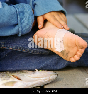 Close-up of a young boy's dirty pied avec une aide de bande sur elle Banque D'Images