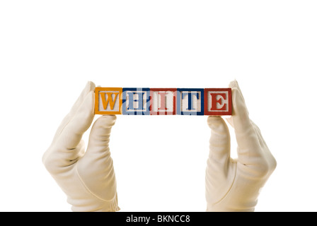 Femme, portant des gants blancs, holding children's blocs qui sort 'white' Banque D'Images