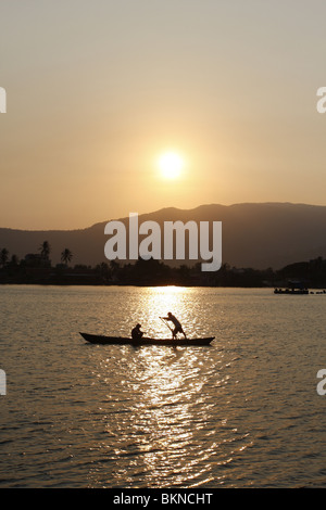 Un couple dans un bateau à rames sur la rivière à Kampot, Cambodge au coucher du soleil Banque D'Images