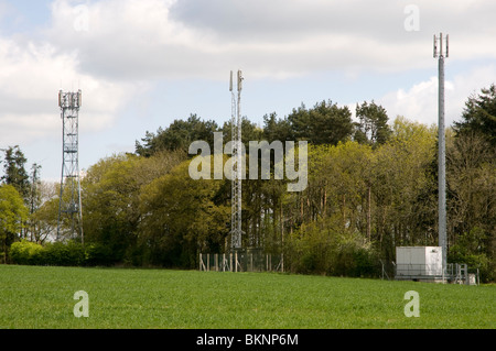 Toi mâts de téléphonie mobile sur les terres agricoles dans la région des Cotswolds Banque D'Images