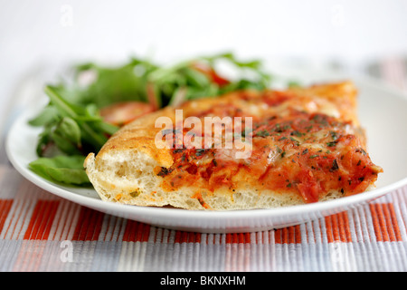 Le style italien traditionnel authentique fromage profonde et Tomato Pizza avec une salade et pas de personnes Banque D'Images