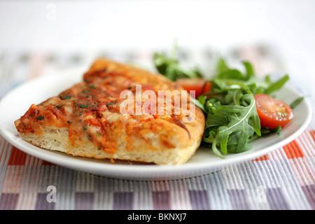 Le style italien traditionnel authentique fromage profonde et Tomato Pizza avec une salade et pas de personnes Banque D'Images