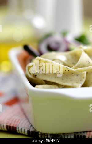 Végétarien fraîchement préparés ou cuits Pâtes Pappardelle avec un mélange de salade du jardin et basilic herbes dans un déjeuner bol avec aucun peuple Banque D'Images