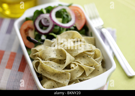 Végétarien fraîchement préparés ou cuits Pâtes Pappardelle avec un mélange de salade du jardin et basilic herbes dans un déjeuner bol avec aucun peuple Banque D'Images