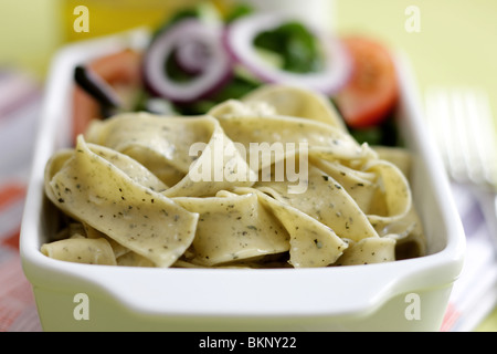 Végétarien fraîchement préparés ou cuits Pâtes Pappardelle avec un mélange de salade du jardin et basilic herbes dans un déjeuner bol avec aucun peuple Banque D'Images