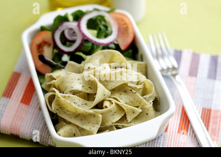 Végétarien fraîchement préparés ou cuits Pâtes Pappardelle avec un mélange de salade du jardin et basilic herbes dans un déjeuner bol avec aucun peuple Banque D'Images