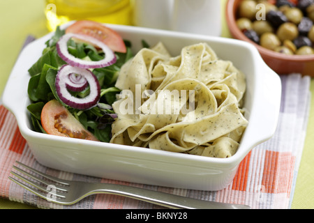 Végétarien fraîchement préparés ou cuits Pâtes Pappardelle avec un mélange de salade du jardin et basilic herbes dans un déjeuner bol avec aucun peuple Banque D'Images