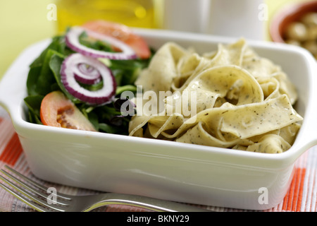 Végétarien fraîchement préparés ou cuits Pâtes Pappardelle avec un mélange de salade du jardin et basilic herbes dans un déjeuner bol avec aucun peuple Banque D'Images