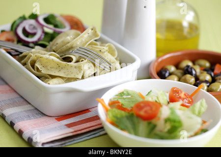 Végétarien fraîchement préparés ou cuits Pâtes Pappardelle avec un mélange de salade du jardin et basilic herbes dans un déjeuner bol avec aucun peuple Banque D'Images