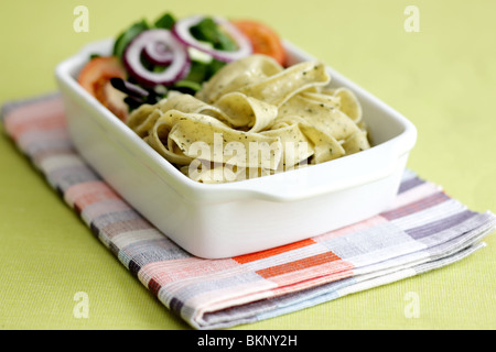 Végétarien fraîchement préparés ou cuits Pâtes Pappardelle avec un mélange de salade du jardin et basilic herbes dans un déjeuner bol avec aucun peuple Banque D'Images