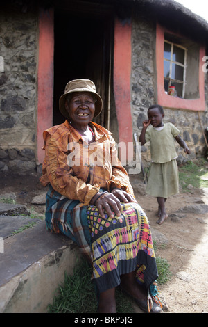 Femme et enfant sur les marches d'une maison traditionnelle en pierre Basotho au Lesotho Banque D'Images