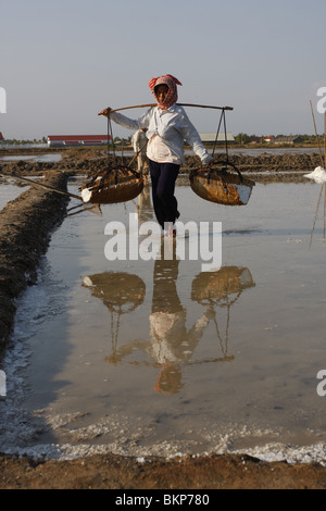 Une femme travaille dans le sel chaud scorchingly de fermes de Kampot, au Cambodge. Banque D'Images