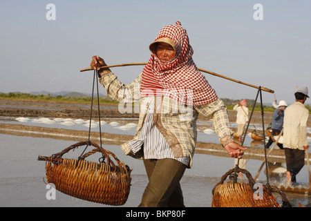 Une femme travaille dans le sel chaud scorchingly de fermes de Kampot, au Cambodge. Banque D'Images