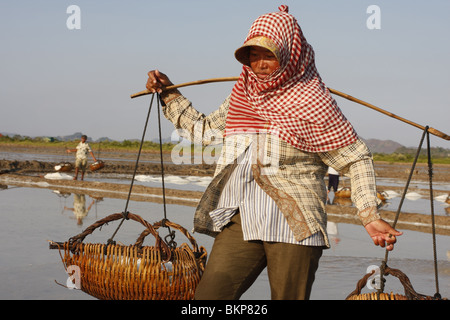 Une femme travaille dans le sel chaud scorchingly de fermes de Kampot, au Cambodge. Banque D'Images