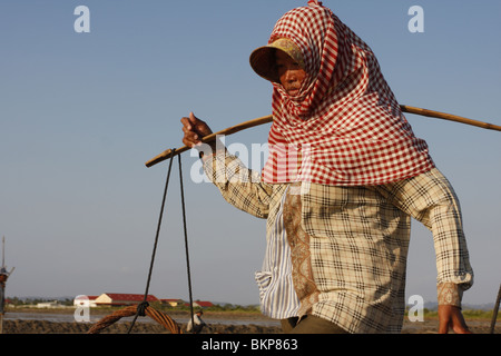 Une femme travaille dans le sel chaud scorchingly de fermes de Kampot, au Cambodge. Banque D'Images