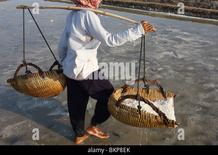 Une femme travaille dans le sel chaud scorchingly de fermes de Kampot, au Cambodge. Banque D'Images